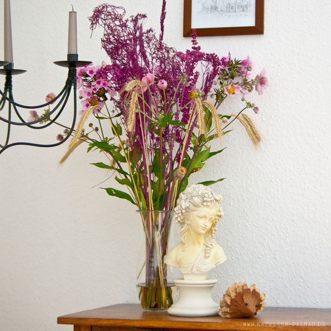 Fertige Vase mit frischen Blumen und farbigen Samenständen